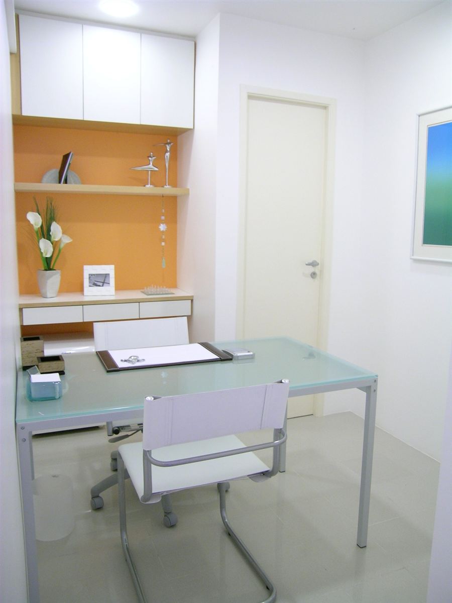 Consultório com mesa de vidro e cadeiras